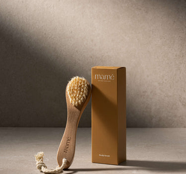 Scrubborstel naast de amberkleurige verpakkingsdoos met opschrift Scalp brush