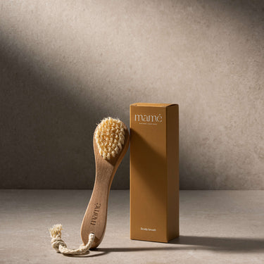 Scrubborstel naast de amberkleurige verpakkingsdoos met opschrift Scalp brush